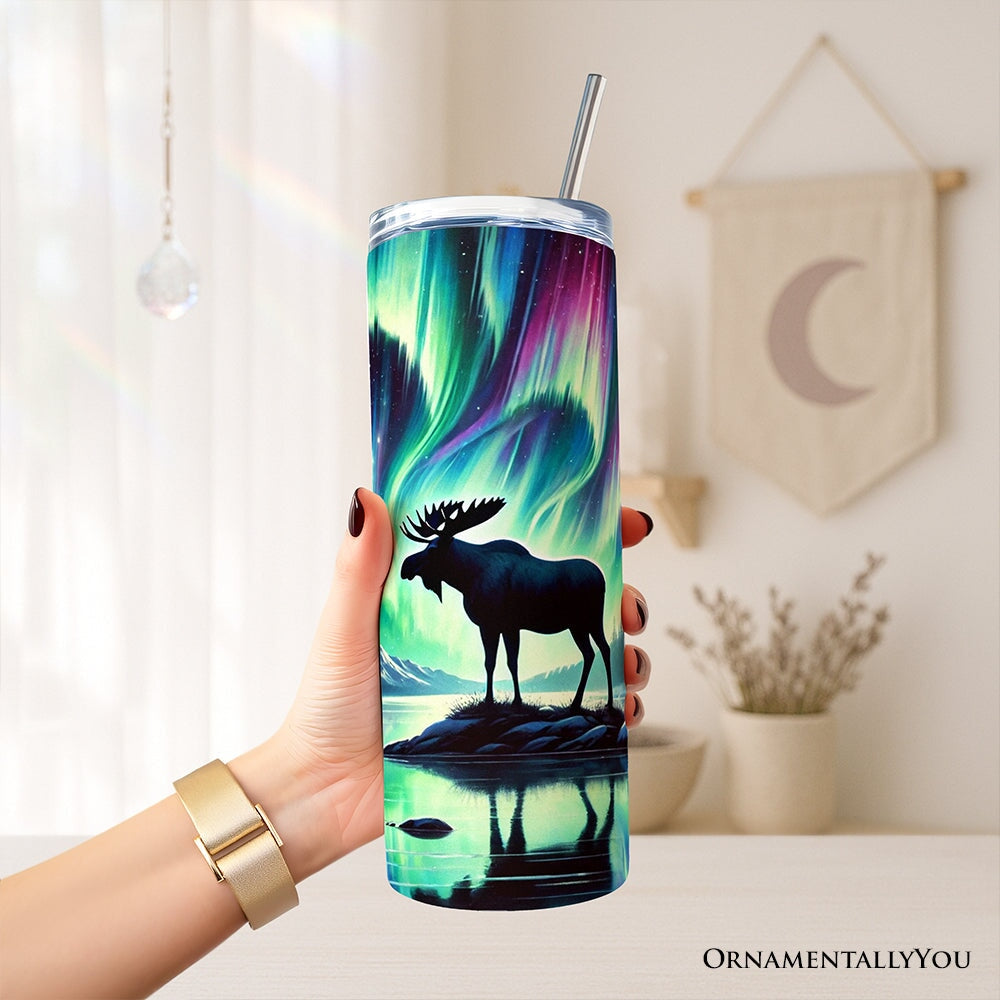 20oz tumbler held in hand with lid and metal straw, aurora moose night scene