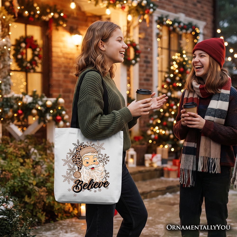 White tote bag with Santa “Believe” print, carried by a woman outdoors