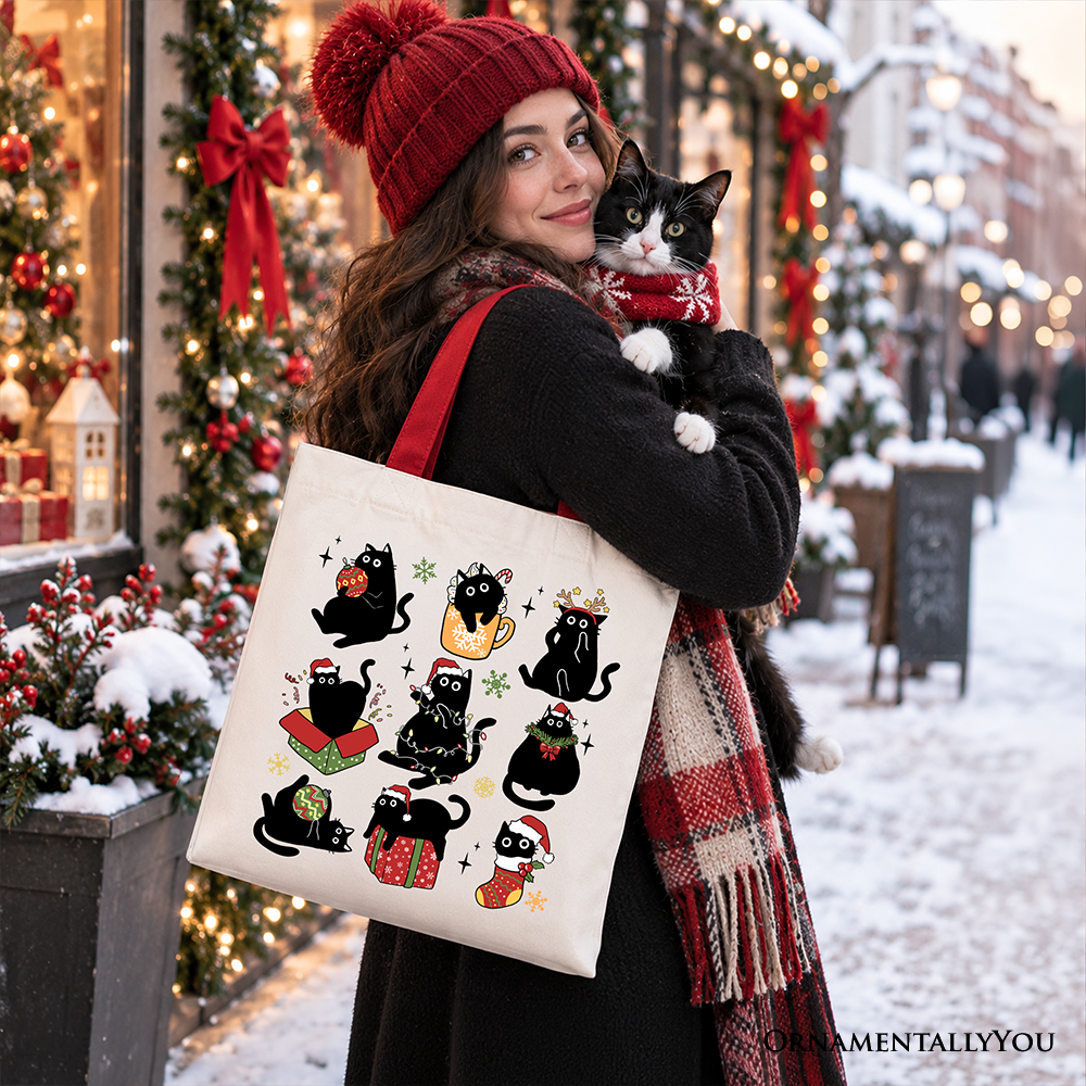 Cotton tote bag held up, showing black cats with Santa hats and festive accessories
