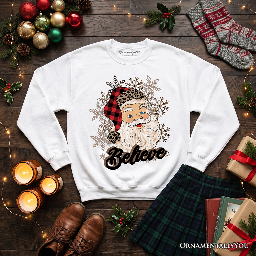 White crewneck sweatshirt with Santa face, snowflake graphic, and 'Believe' print