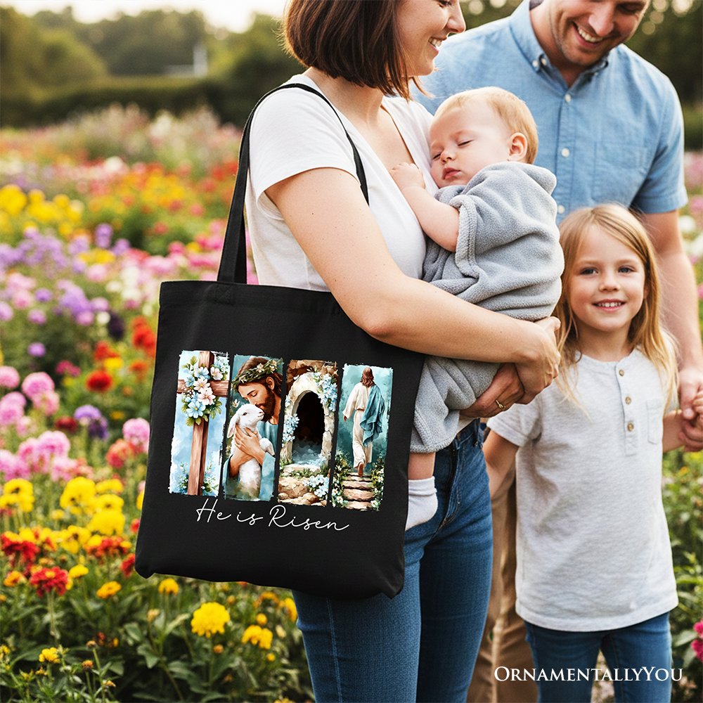 Black canvas tote bag with floral arch collage and "He Is Risen" script on front.