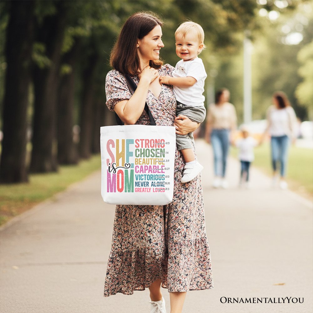 White canvas tote bag with navy handles and colorful affirmation print, held in hand