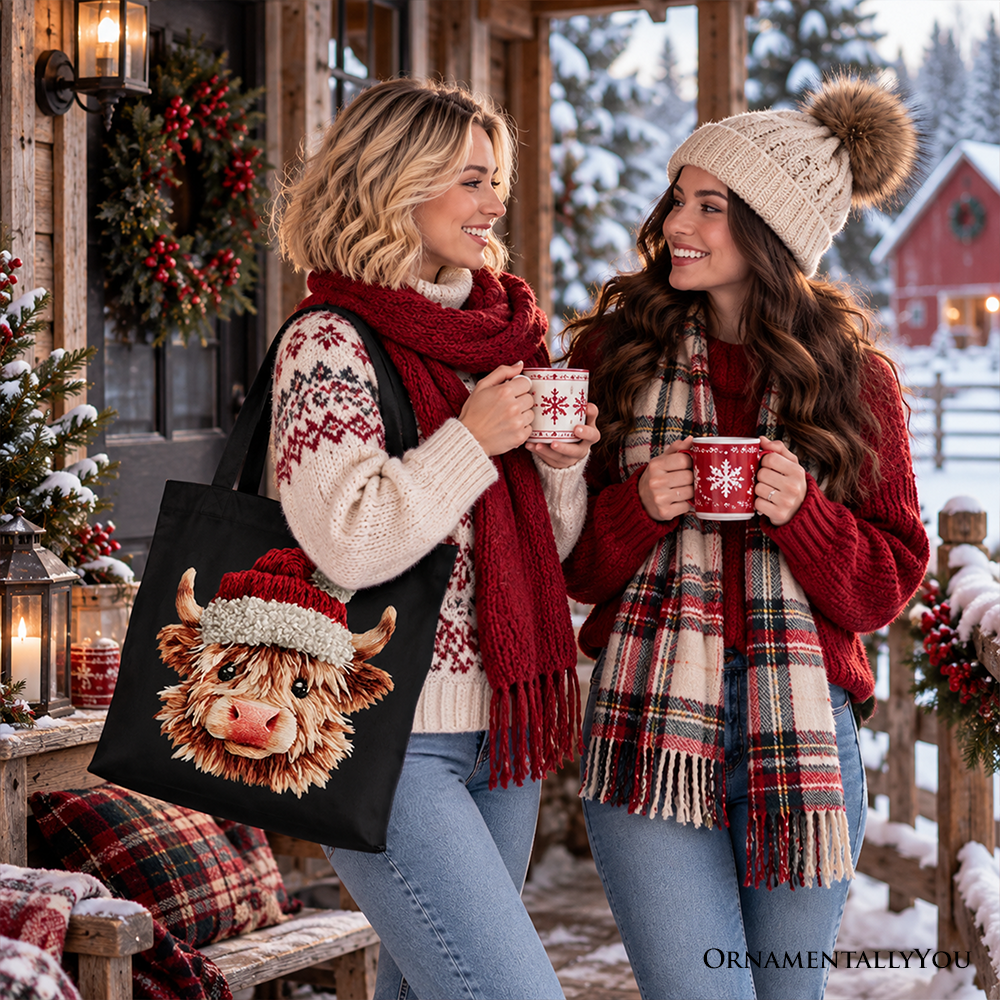 Black tote bag with Highland cow Santa hat graphic, held by shopper