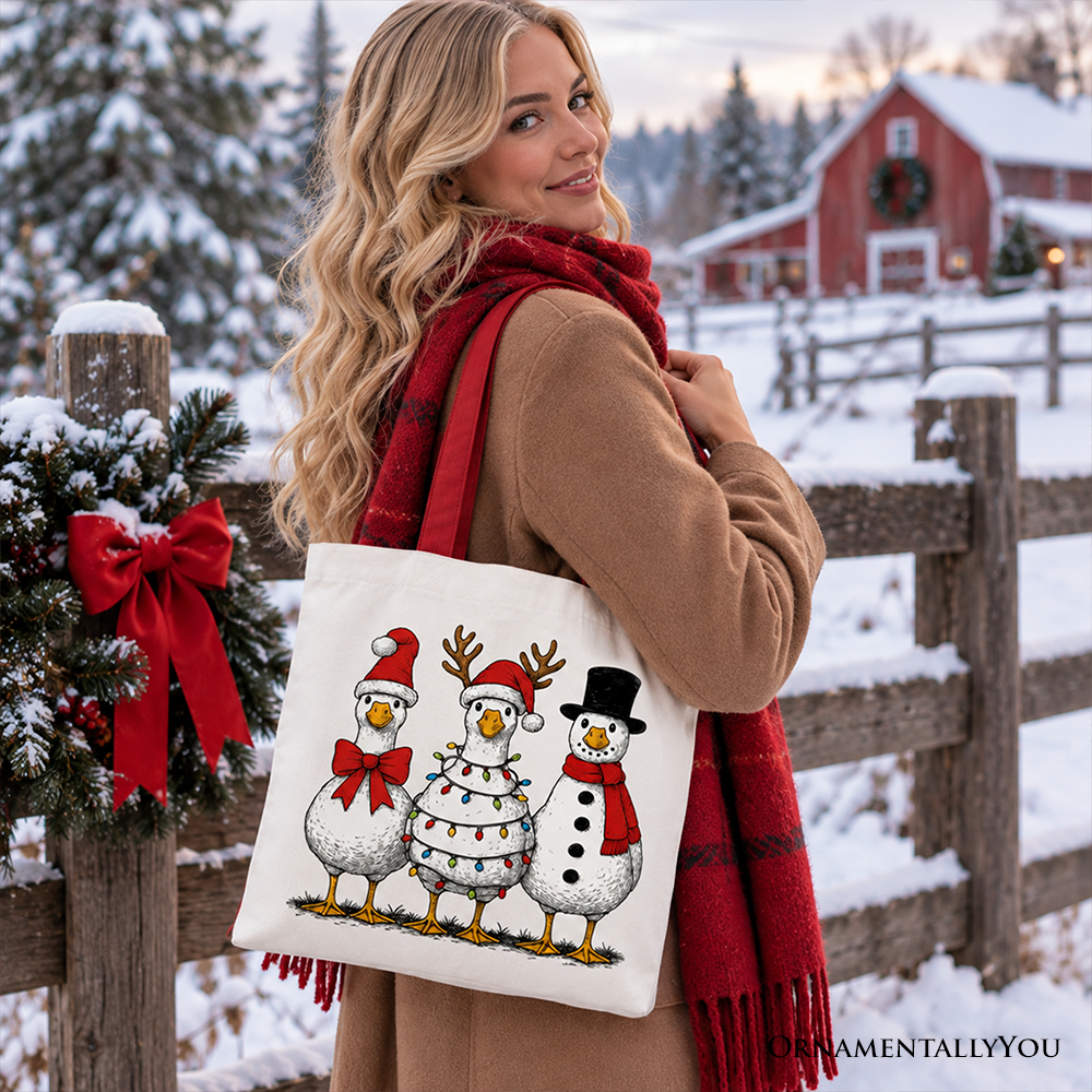 White tote bag with three cartoon snowmen wearing red scarves and black hats, cream handles