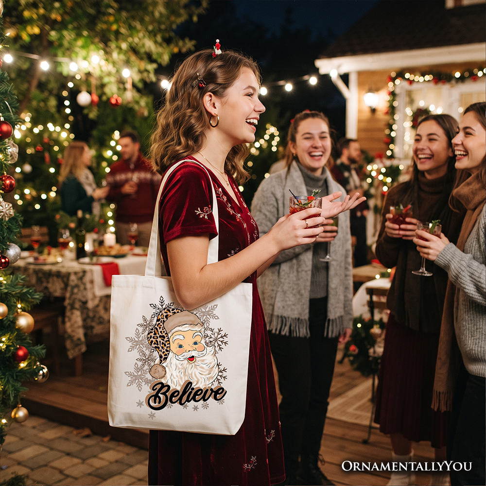White tote bag with Santa “Believe” design, carried by a woman at a Christmas gathering
