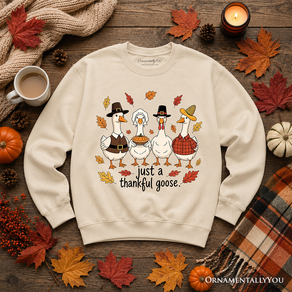 Cream sweatshirt laid flat with “just a thankful goose” turkey graphic and leaves