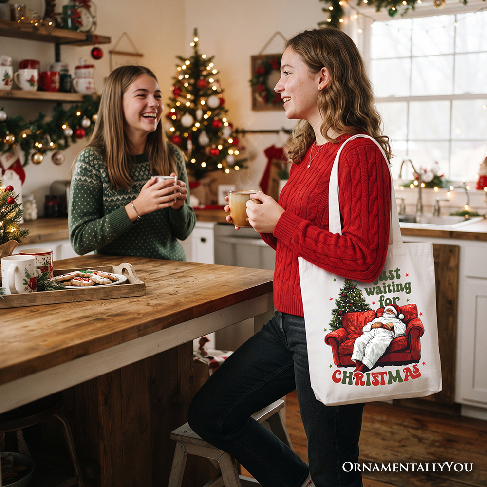 Cream tote bag carried by two people, Santa-on-couch 'Just waiting for Christmas' print