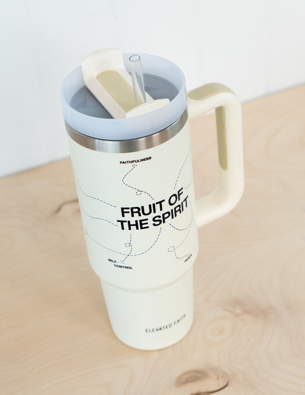 30 oz cream tumbler with open lid, clear straw, silver rim, 'Fruit of the Spirit' logo