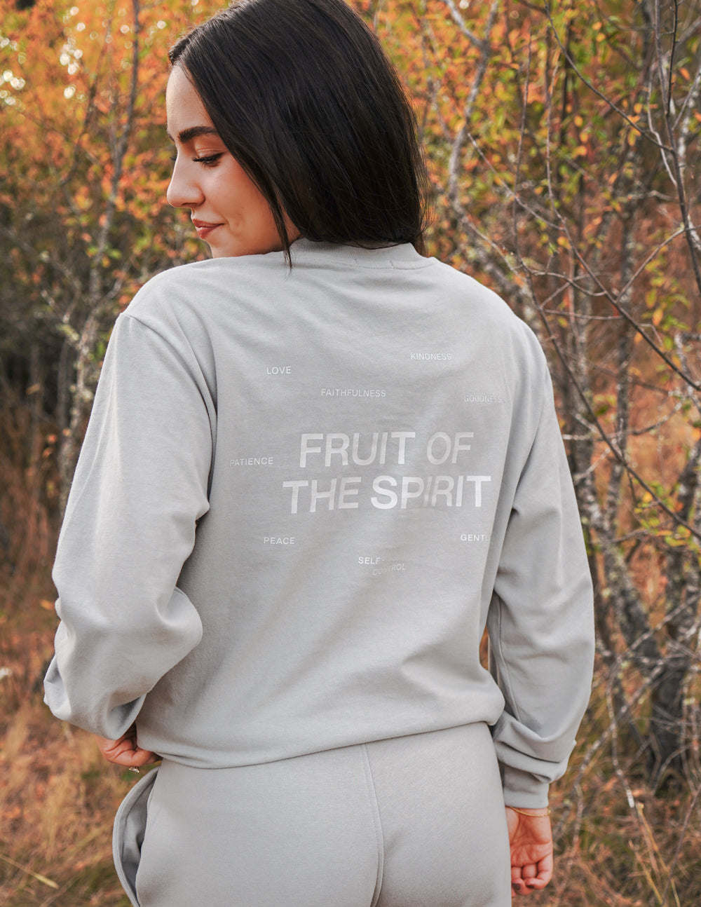 Back view of grey long-sleeve T-shirt with “FRUIT OF THE SPIRIT” text print.