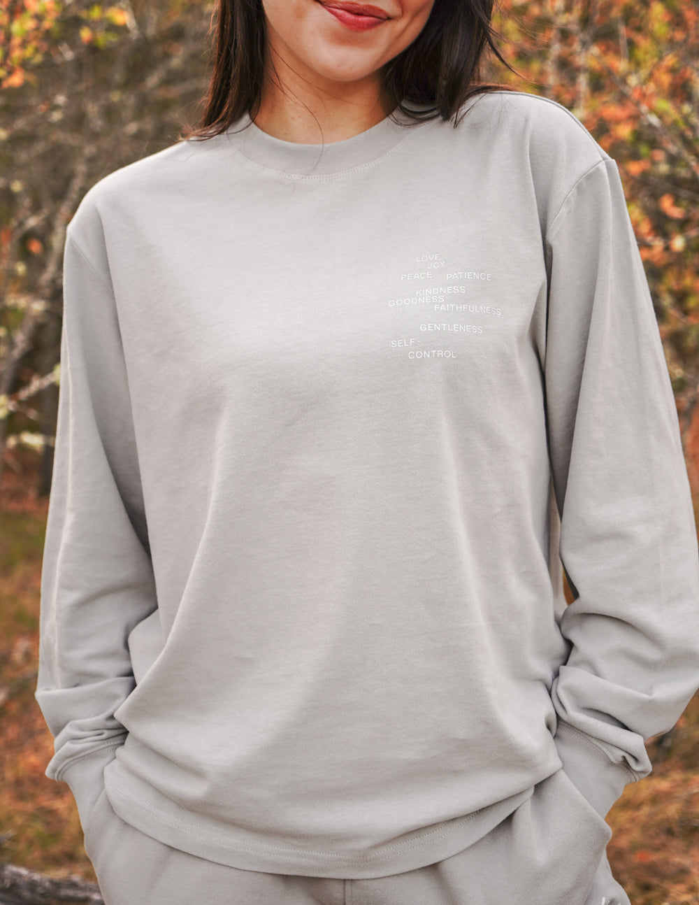 Grey long-sleeve T-shirt with crew neck and small chest text print.