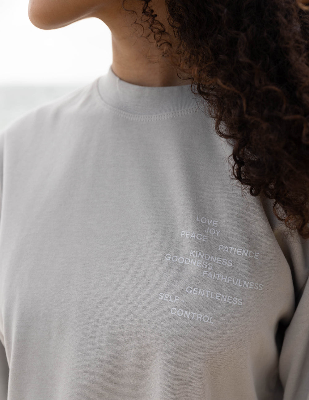 Grey long-sleeve T-shirt neckline with partial word list text at the chest.