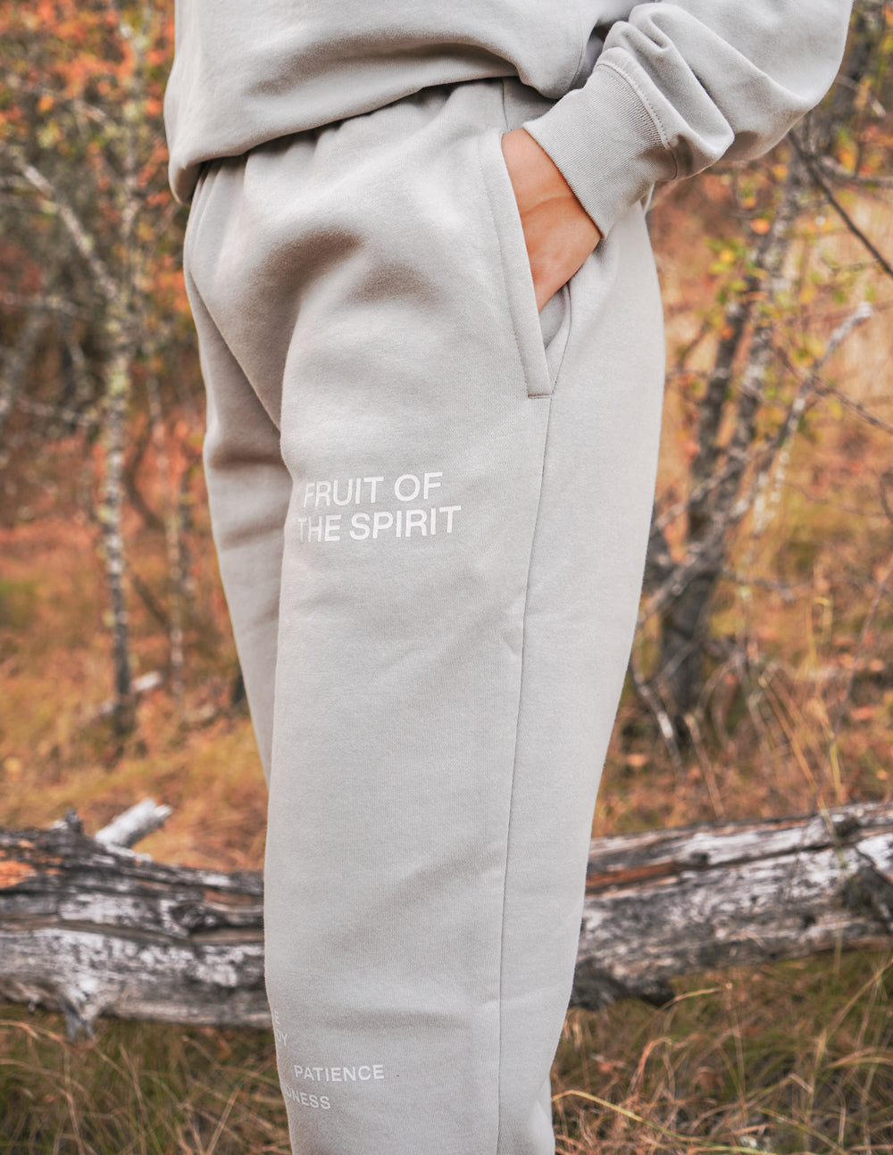 Grey unisex sweatpants with front thigh logo and tapered ankle cuffs