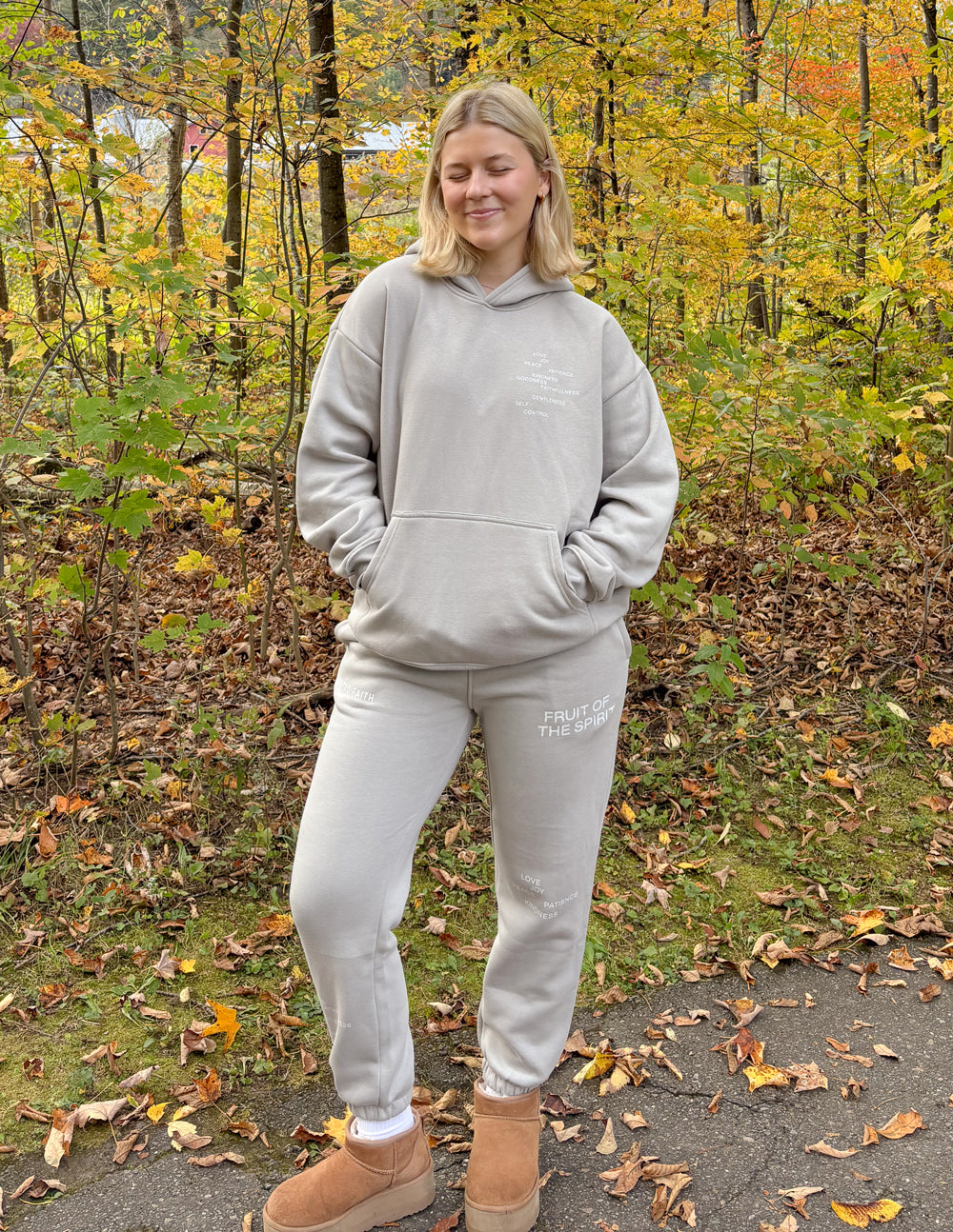 Grey unisex sweatpants on model with cuffed hems and logo on leg