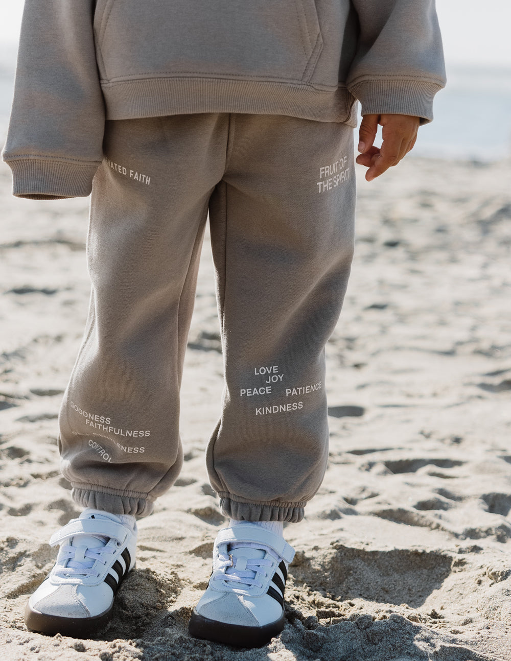 Kids sweatpants in heather gray with printed virtue words on the front legs