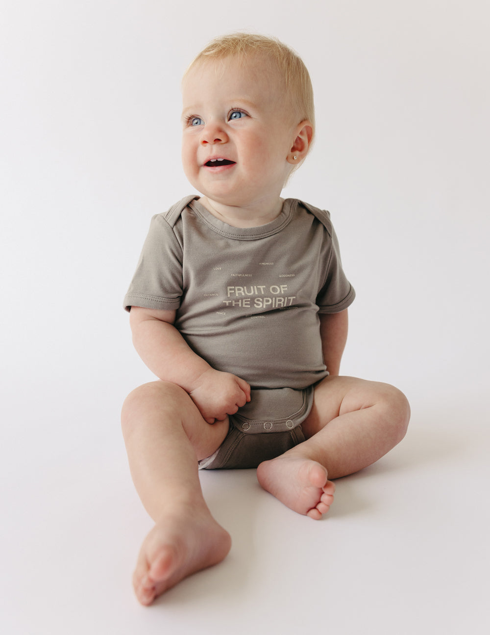 Taupe short-sleeve baby onesie with 'Fruit of the Spirit' chest graphic