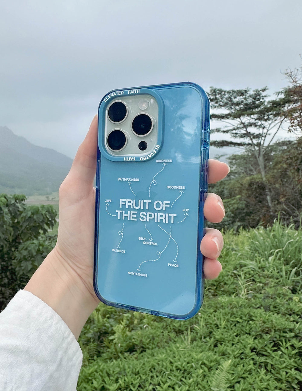 Blue Fruit of the Spirit phone case held up; clear back with “FRUIT OF THE SPIRIT” text