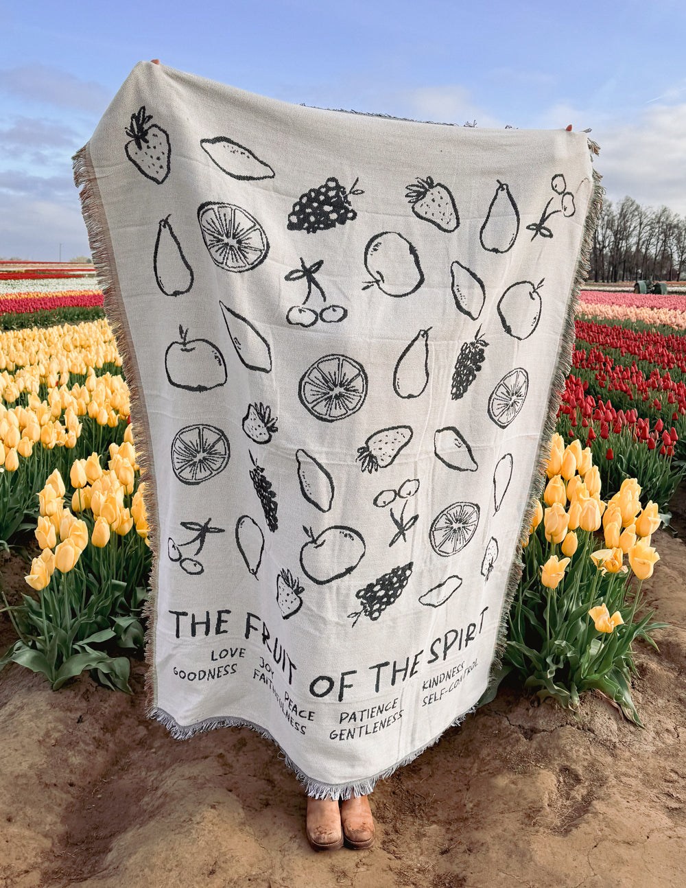 Cream throw blanket with black fruit icon print and fringe edge