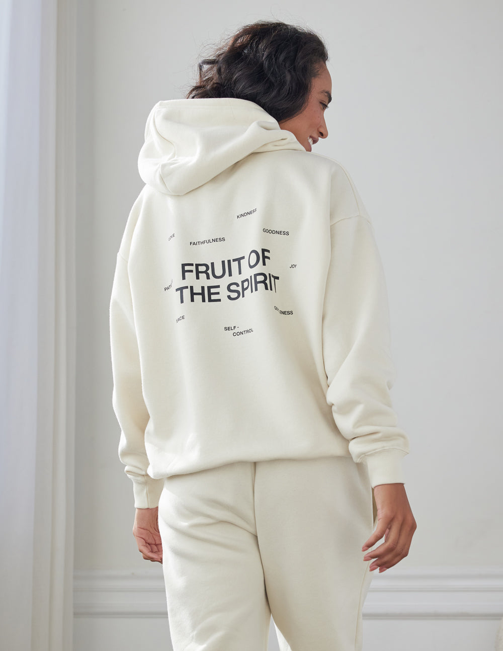 Off-white unisex hoodie with large back print reading “FRUIT OF THE SPIRIT”