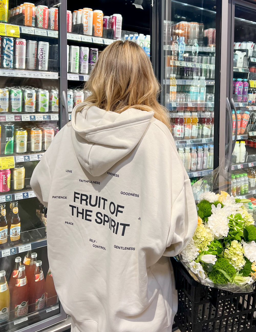 Off-white unisex hoodie with hood and large back print in store setting