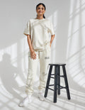 Unisex cream sweatpants with printed leg text and tapered ankle cuffs