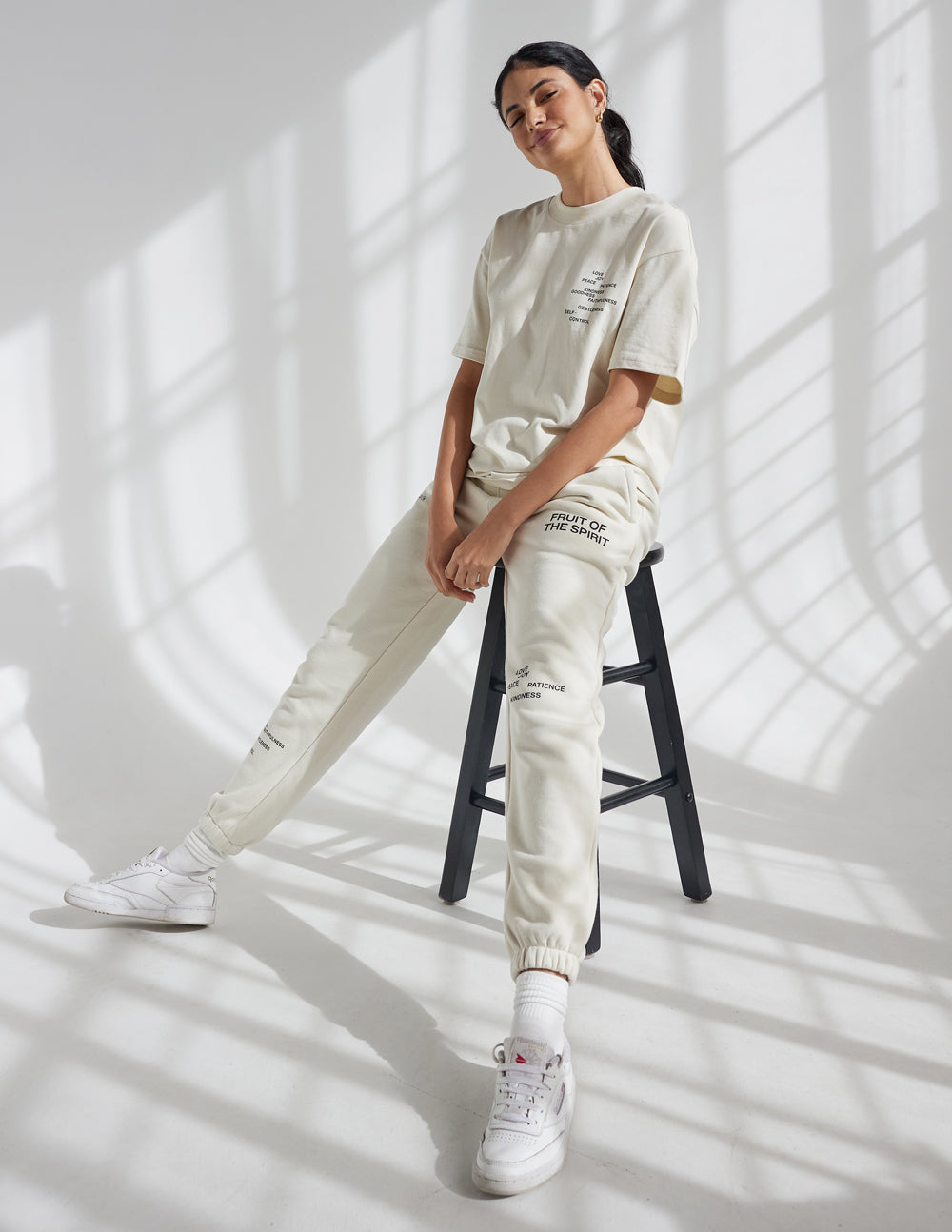Unisex cream jogger sweatpants with cuffed ankles and printed leg graphic