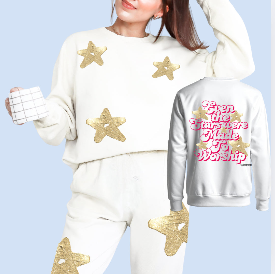 Cream sweatsuit set with sweatshirt and pants, gold stars and “Even the stars…” graphic