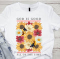 White graphic T-shirt with 'God is Good' text and colorful sunflower floral design
