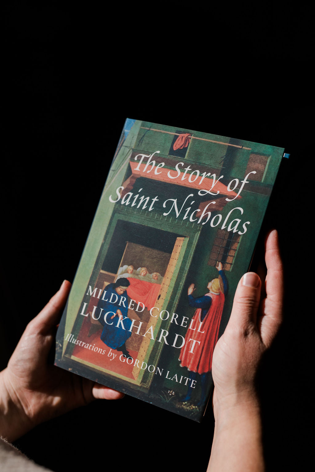 Illustrated storybook cover with title text held by two hands
