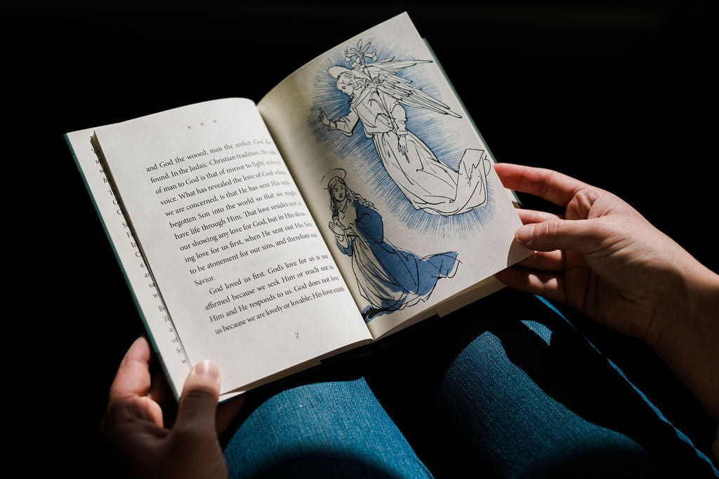 Christmas book open, featuring a large angel illustration on the right page