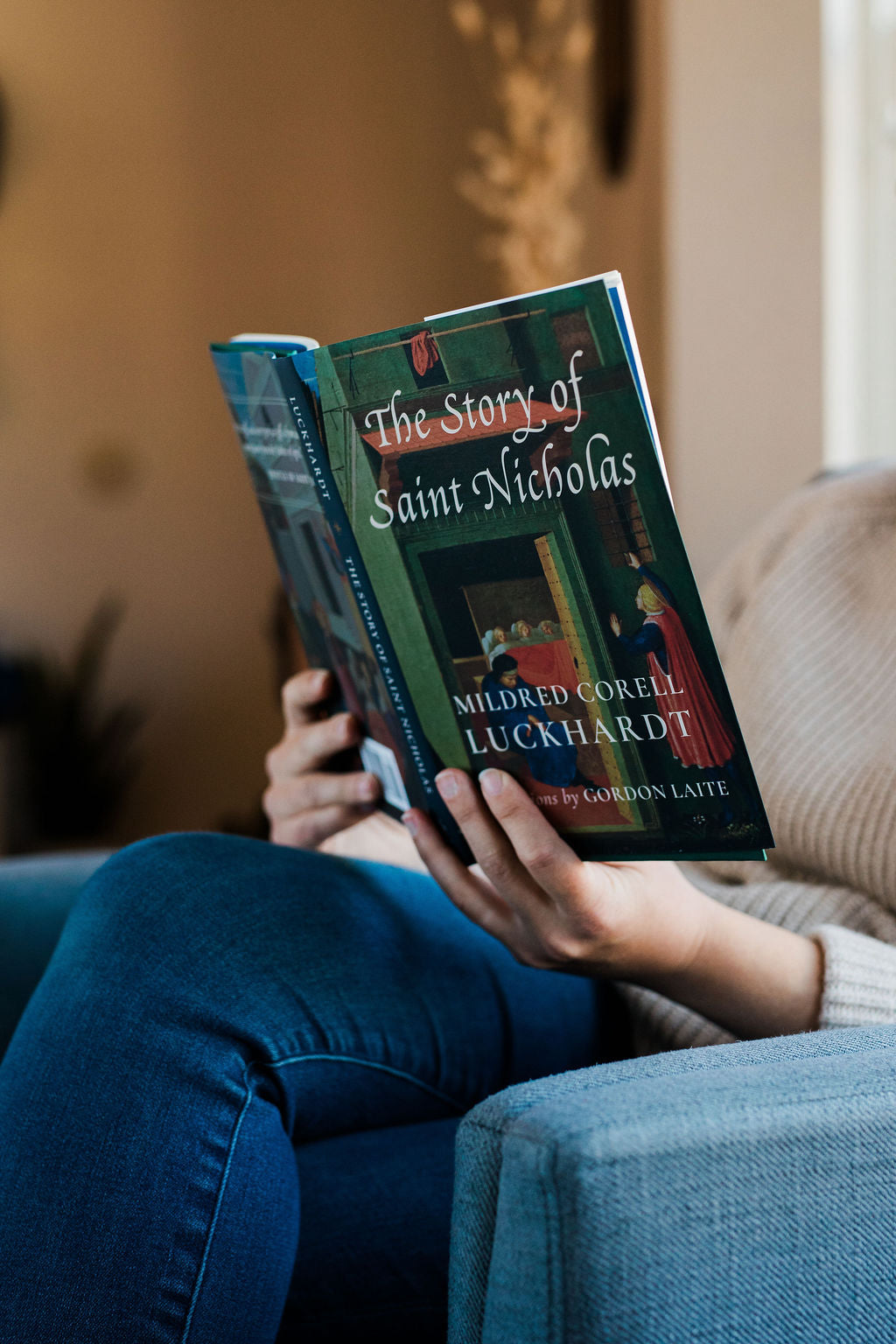 Blue illustrated storybook with title text, held on a sofa