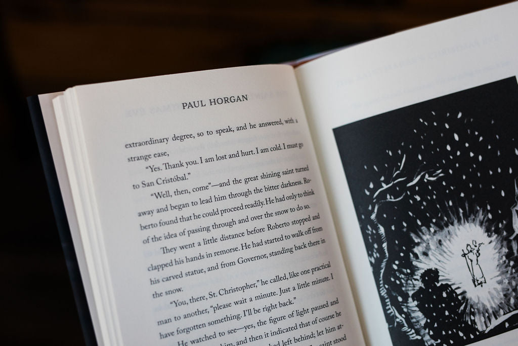 Open book with printed text and a circular ink-style illustration