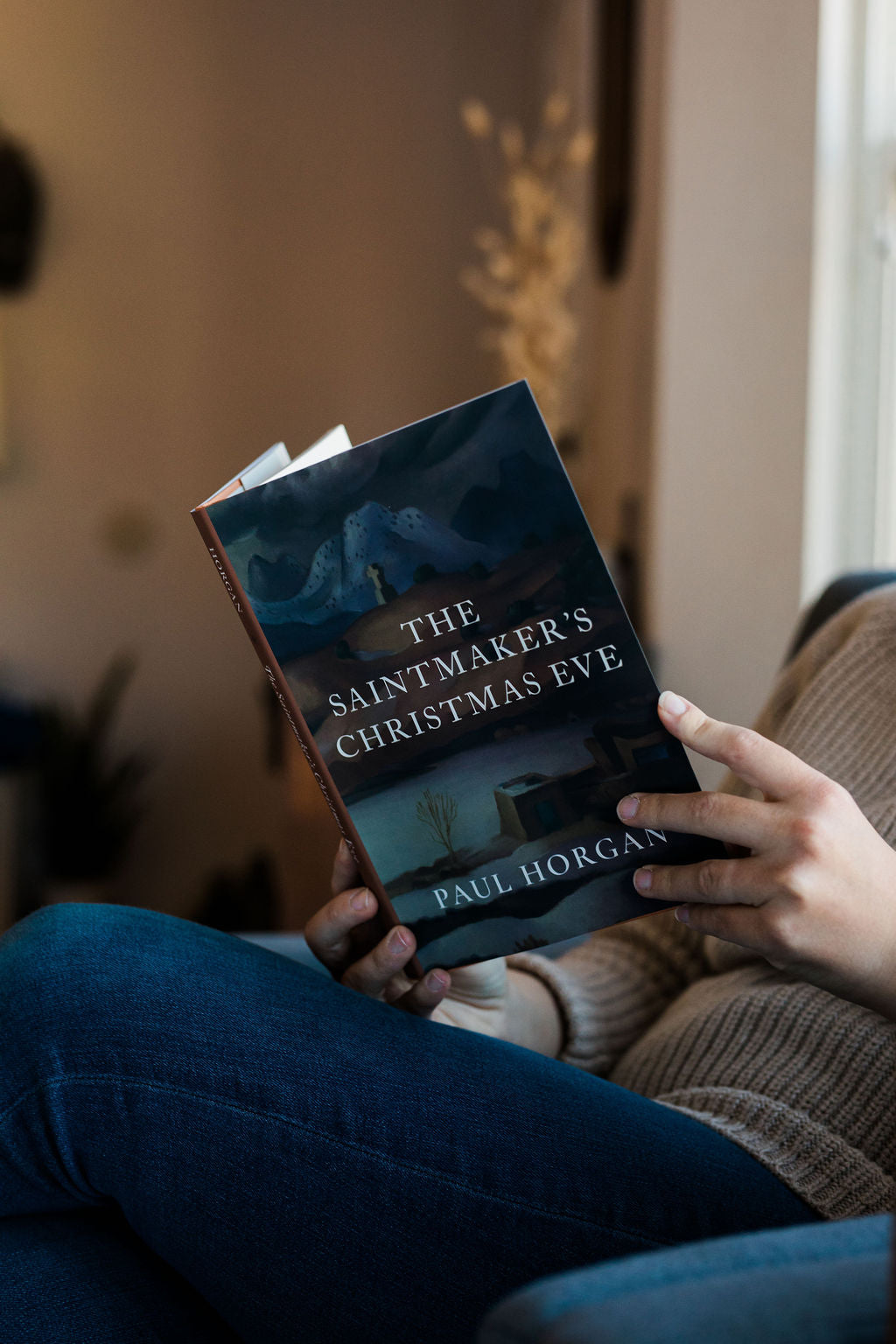 Hardcover book with illustrated Christmas Eve cover held in hands