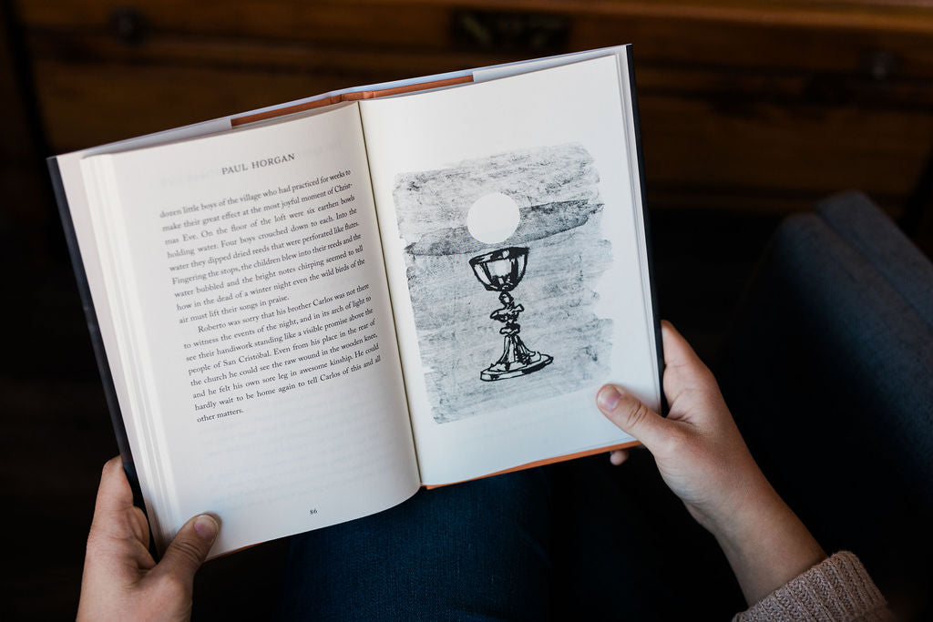Open book with text and engraved-style goblet drawing