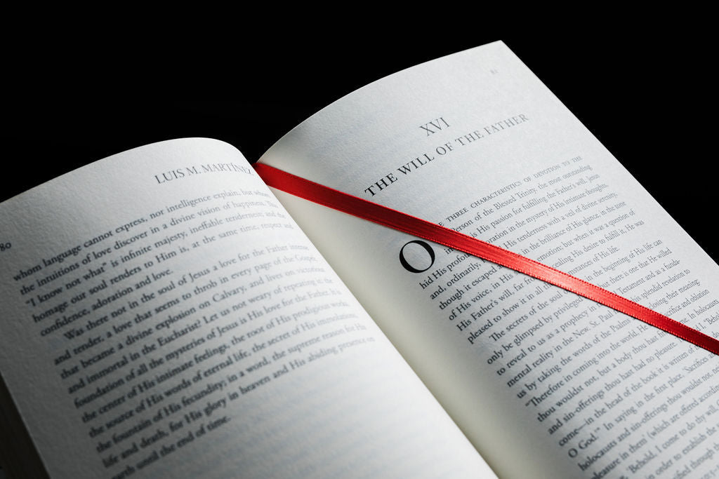 Open Holy Spirit book with text pages and a red ribbon bookmark
