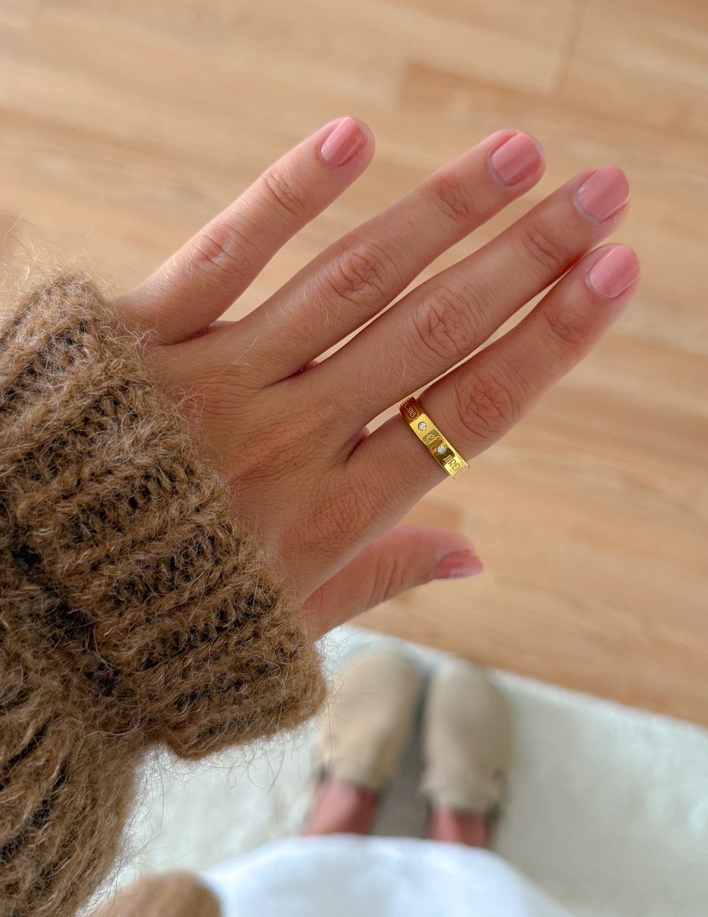 Gold-tone gemstone logo ring with engraved face and small gemstone accents