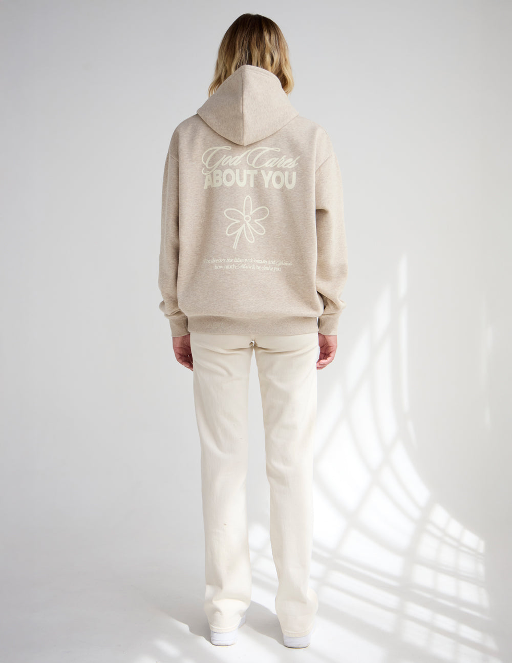 Light beige unisex hoodie, back shows "ABOUT YOU" text and flower logo