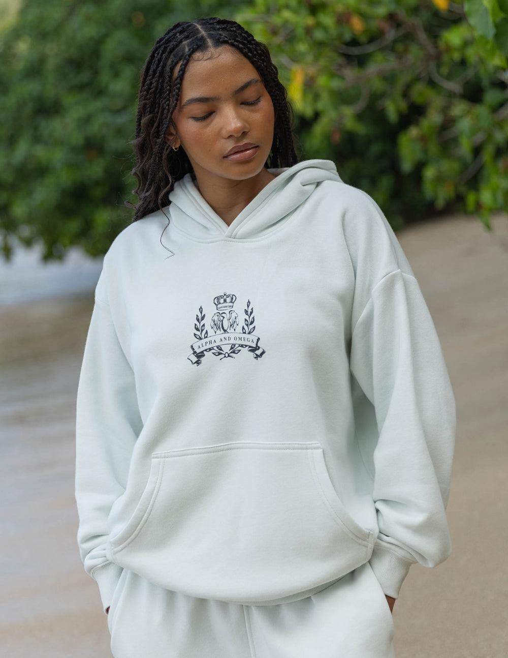 Unisex light cream pullover hoodie with embroidered chest crest and kangaroo pocket