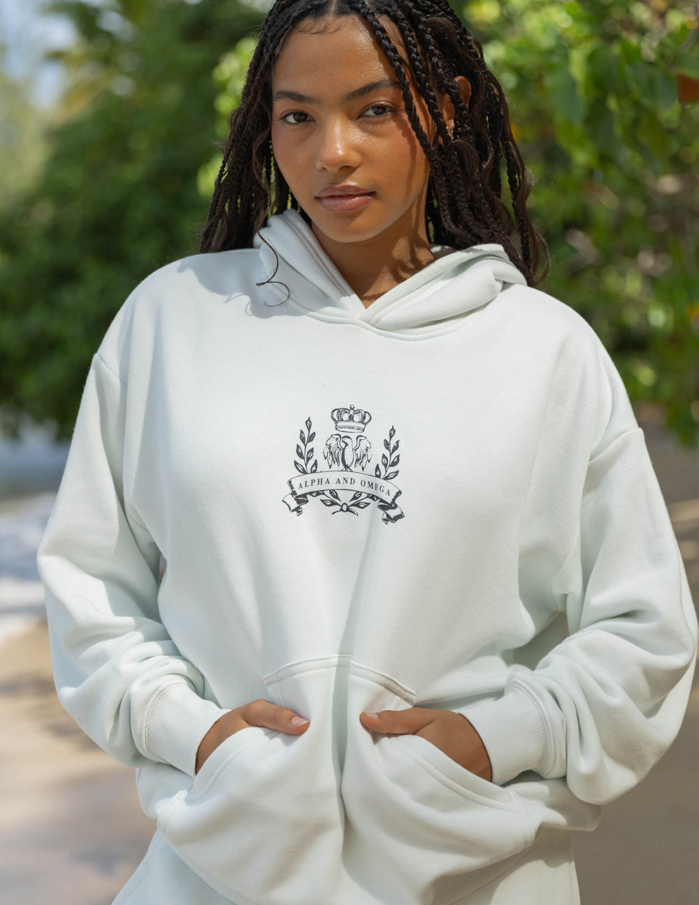 Unisex light cream hoodie with embroidered chest crest and drawstring hood