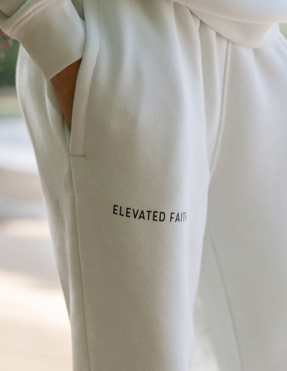 Unisex sweatpants, off-white, “ELEVATED FAITH” logo on thigh