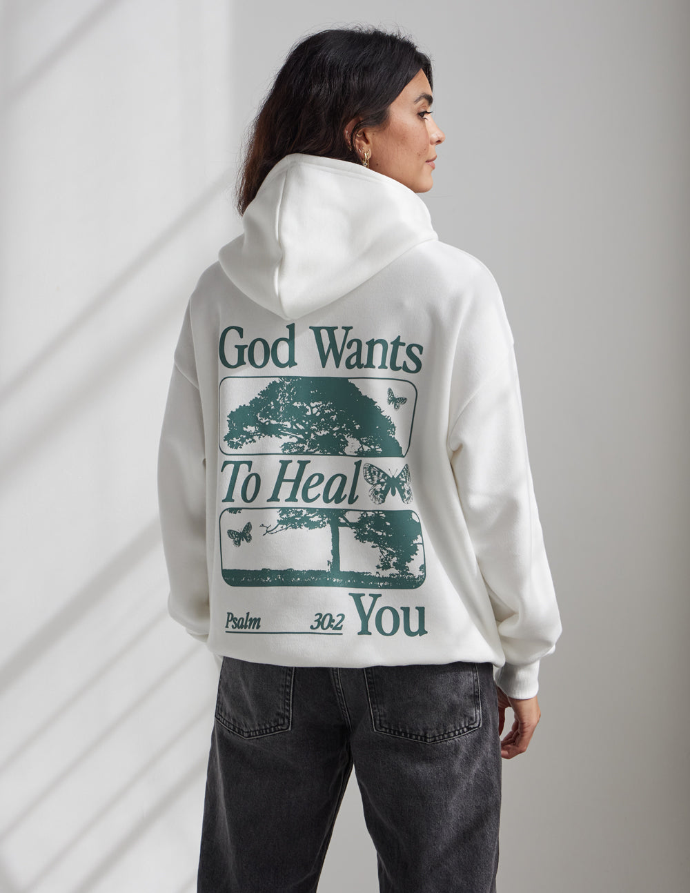 White unisex hoodie with back text "God Wants To Heal You" graphic print