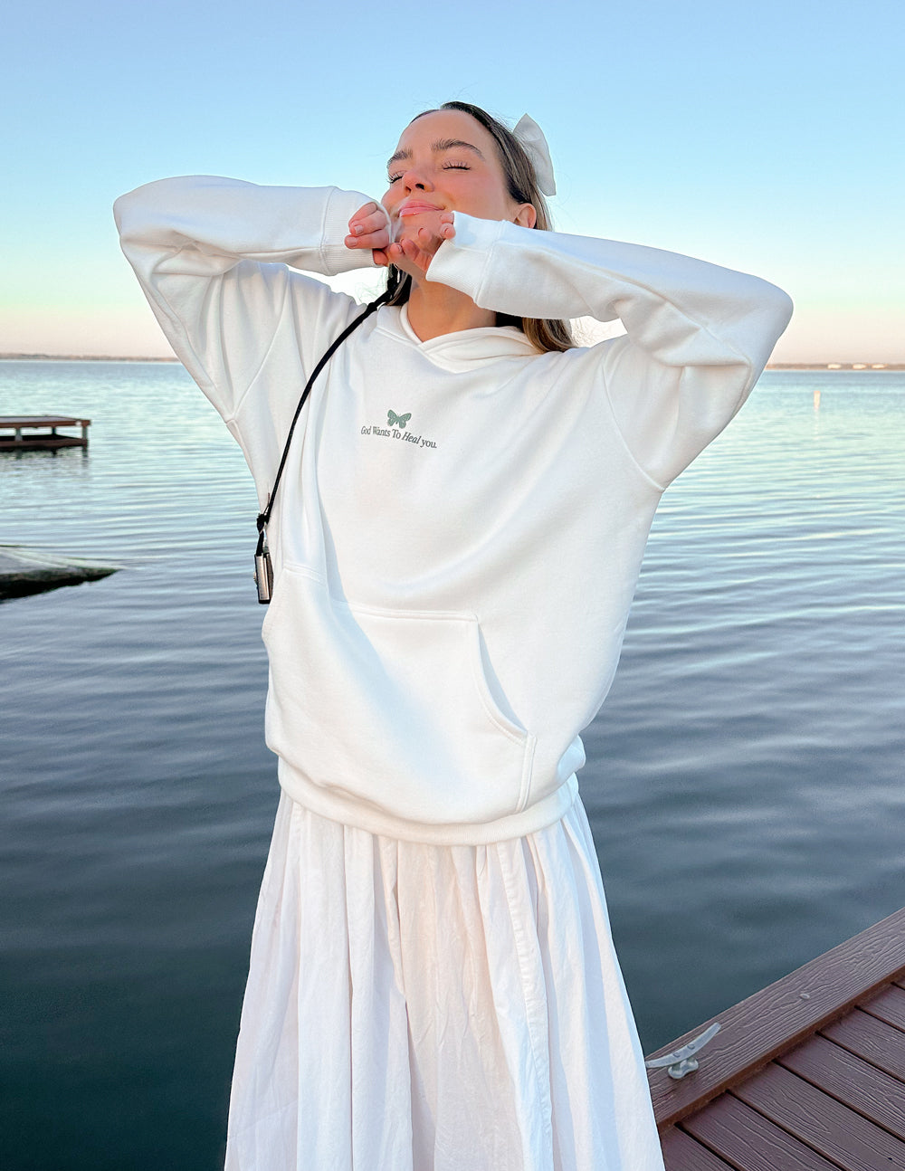 White unisex hoodie with small green chest logo and drawstring hood