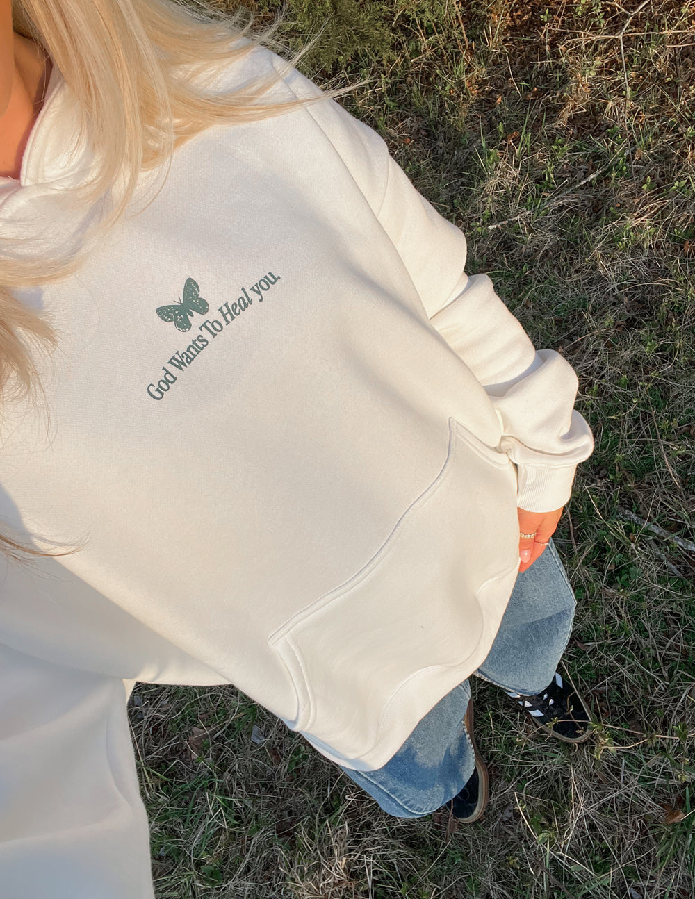 White unisex hoodie sleeve with green printed text and tree graphic