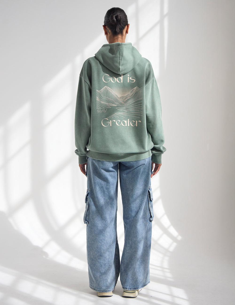 Sage green unisex hoodie with “God is Greater” back graphic and pullover hood