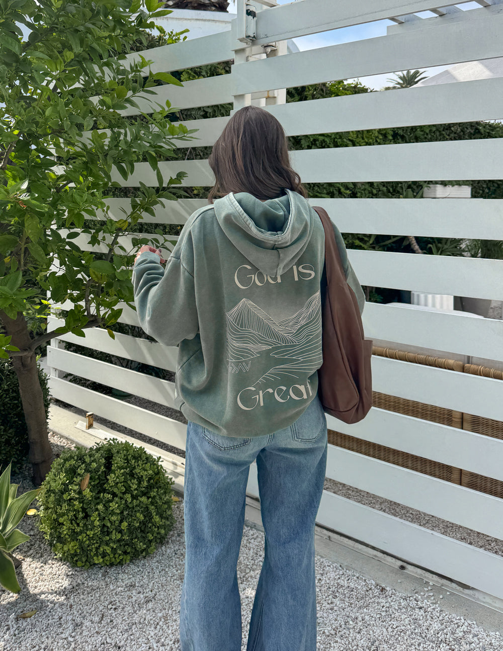 Sage green unisex hoodie with “God is Greater” back print and front kangaroo pocket