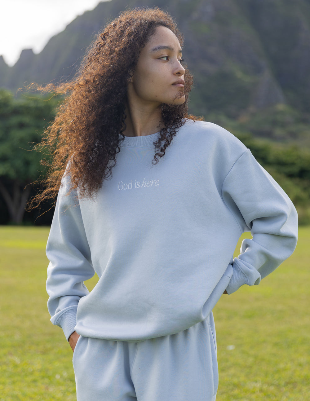 Light blue unisex crewneck sweatshirt with God Is Here chest text