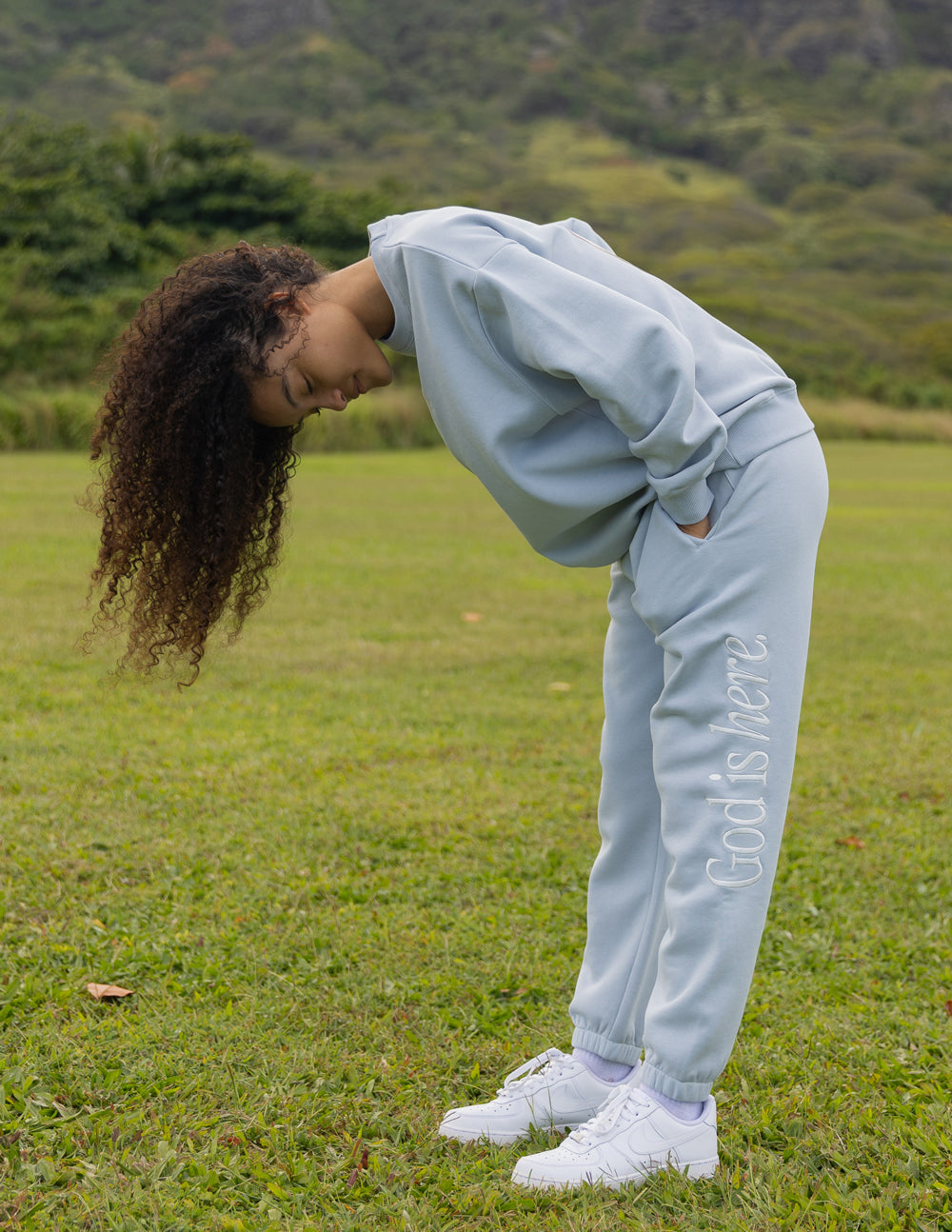 Light blue unisex sweatpants with 'God is here' print and cuffed hem