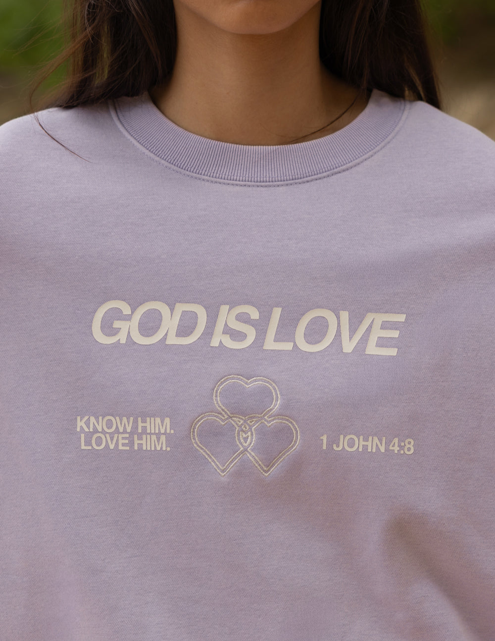 Lavender crewneck sweatshirt chest print: “GOD IS LOVE” with hearts and verse