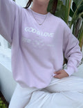 Lavender unisex crewneck sweatshirt with “GOD IS LOVE” text and heart graphic
