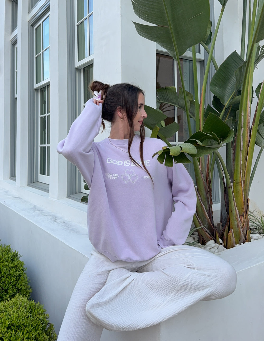 Lavender unisex crewneck sweatshirt worn with back print and heart graphic
