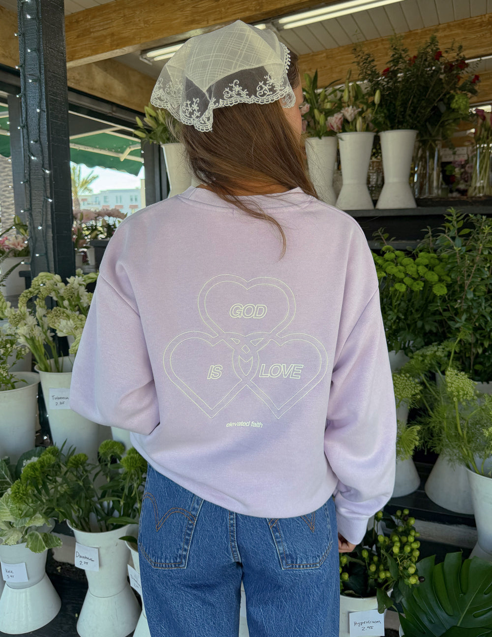 Lavender crewneck sweatshirt back view with “GOD IS LOVE” heart graphic